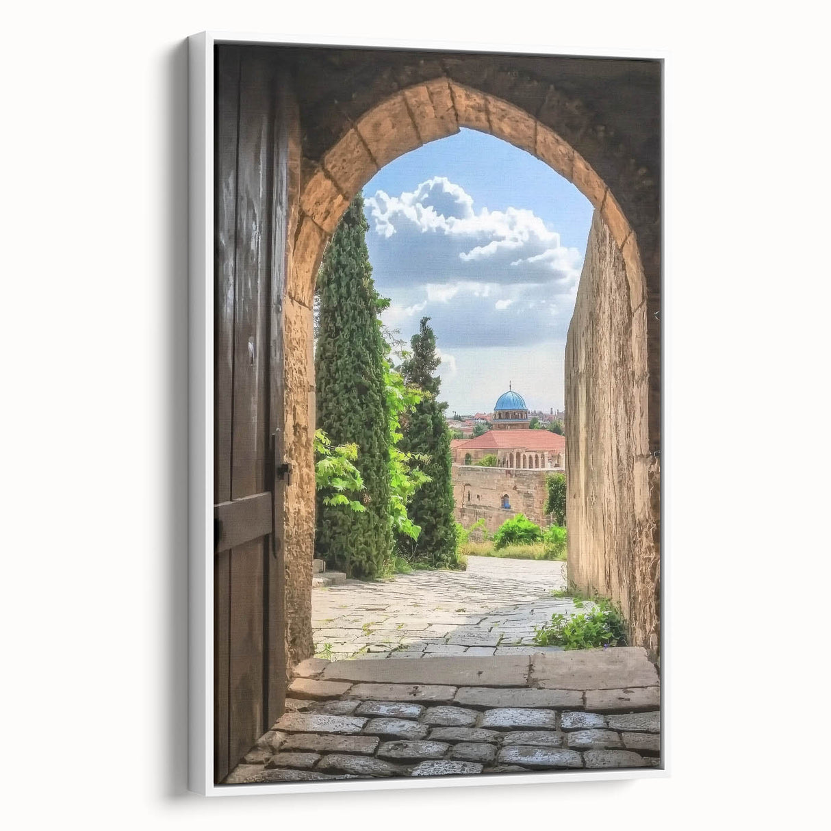 Framed canvas artwork depicting a picturesque landscape with a medieval castle surrounded by lush greenery, presented in a sleek white frame, ideal for home decor.