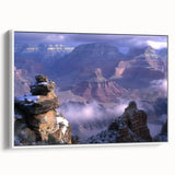 Framed canvas artwork depicting a stunning landscape of canyons, showcasing vibrant colors and intricate details. The piece is elegantly displayed with a white frame, ideal for enhancing home decor.