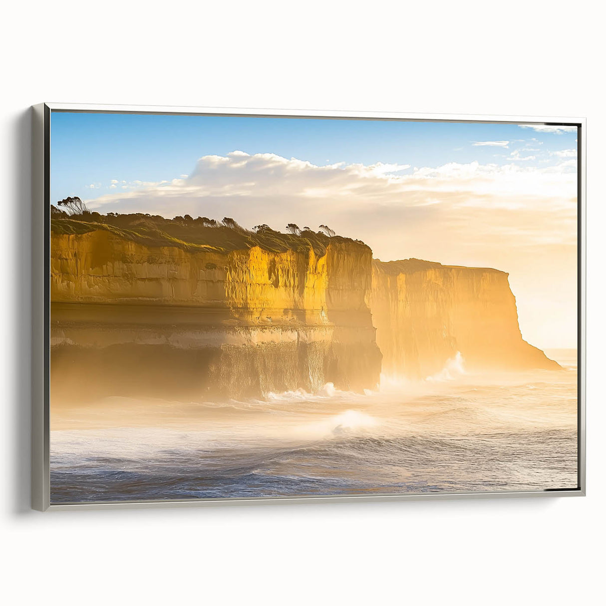 Framed canvas artwork depicting a dramatic landscape of cliffs under a vibrant sunset, featuring a silver frame that enhances the visual appeal, perfect for home decor.