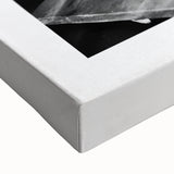 Large art of a black and white landscape painting on stretched canvas, depicting people in a market.