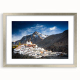 Textured art depicting an abstract Tibetan landscape in muted earth tones on a framed silver mat, ideal for bedroom art.