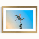 Abstract art print of Piccadilly, England in muted gold and blue tones, framed with a gold mat.