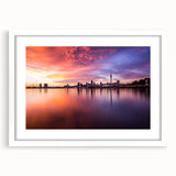 Abstract art print of Auckland skyline in muted blue and gray tones on a framed white mat, ideal for dining room decor.