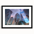 Abstract art print of Manhattan skyline in muted gray and blue tones, framed with a black mat.
