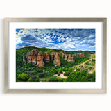 Silver-framed landscape artwork featuring dramatic cliffs and serene scenery, beautifully matted for a polished presentation, ideal for home decor enhancement.