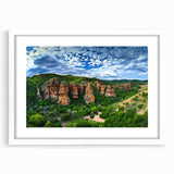 Framed landscape artwork depicting dramatic cliffs in vibrant colors, featuring a white mat and a sleek frame, perfect for enhancing modern home decor.