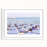 Abstract art print featuring swirls of blue and green, framed in white, suitable for bedroom or dining room decor.