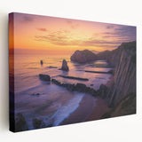 Stretched canvas artwork depicting a dramatic cliff landscape at sunset, featuring vibrant colors and intricate details, perfect for enhancing any home decor.