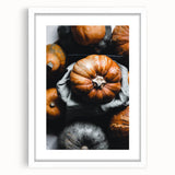 Abstract art print depicting autumnal trees in orange and red hues, framed in white.