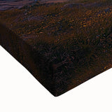 Close-up of a stretched canvas depicting a vibrant landscape with dramatic cliffs and a serene sky, ideal for enhancing home decor with natural beauty.