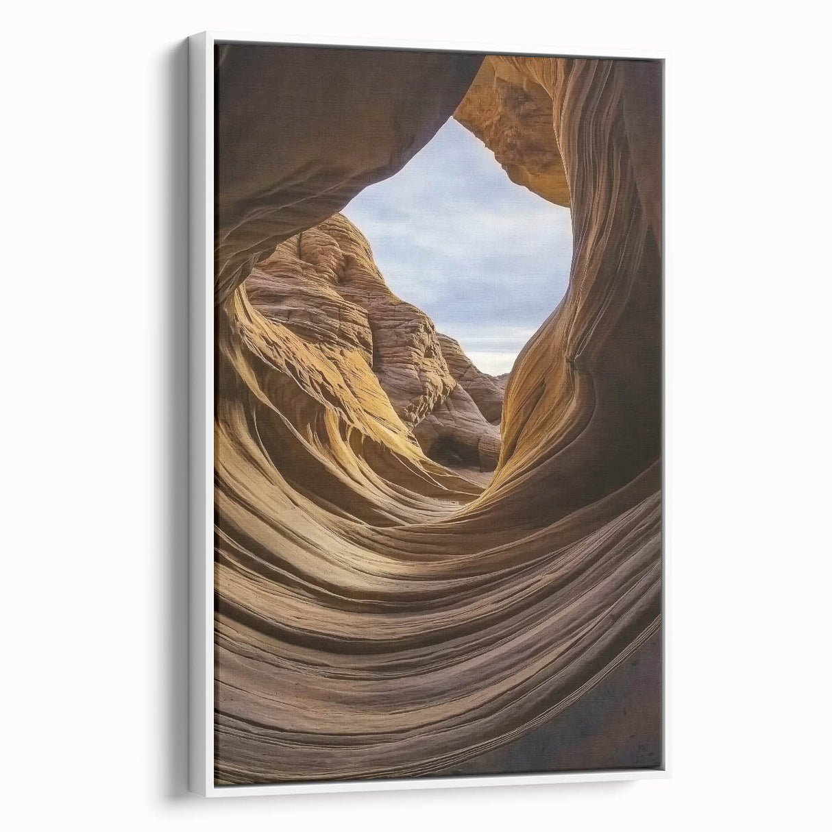 Framed canvas artwork depicting a stunning landscape of canyons, showcasing vibrant hues of orange and blue, set against a white frame for an elegant finish.