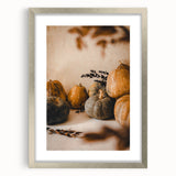 Textured abstract art print depicting fall colors in muted orange and brown tones, framed in silver.
