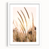 Abstract art print in vibrant orange and yellow tones, framed in white, suitable for bedroom or dining room decor.