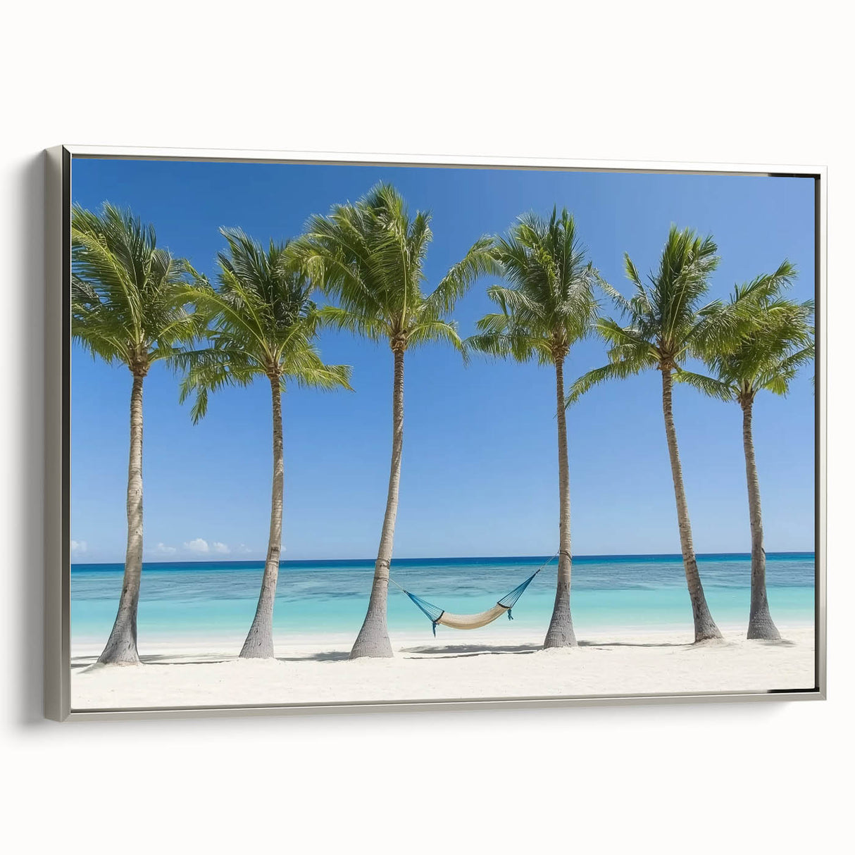 Framed landscape canvas artwork showcasing a serene beach scene with gentle waves and soft golden sands, bordered by a sleek silver frame, ideal for coastal home decor.