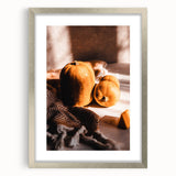 Textured abstract art print depicting autumn themes in warm orange and brown tones, framed in silver.