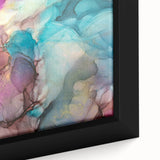 Close-up of a framed canvas showcasing vibrant abstract splatters in hues of blue, orange, and yellow, perfect for modern home decor or art enthusiasts.