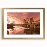 Abstract art print of a European scenery with muted earth tones in a gold frame, ideal for dining room decor.