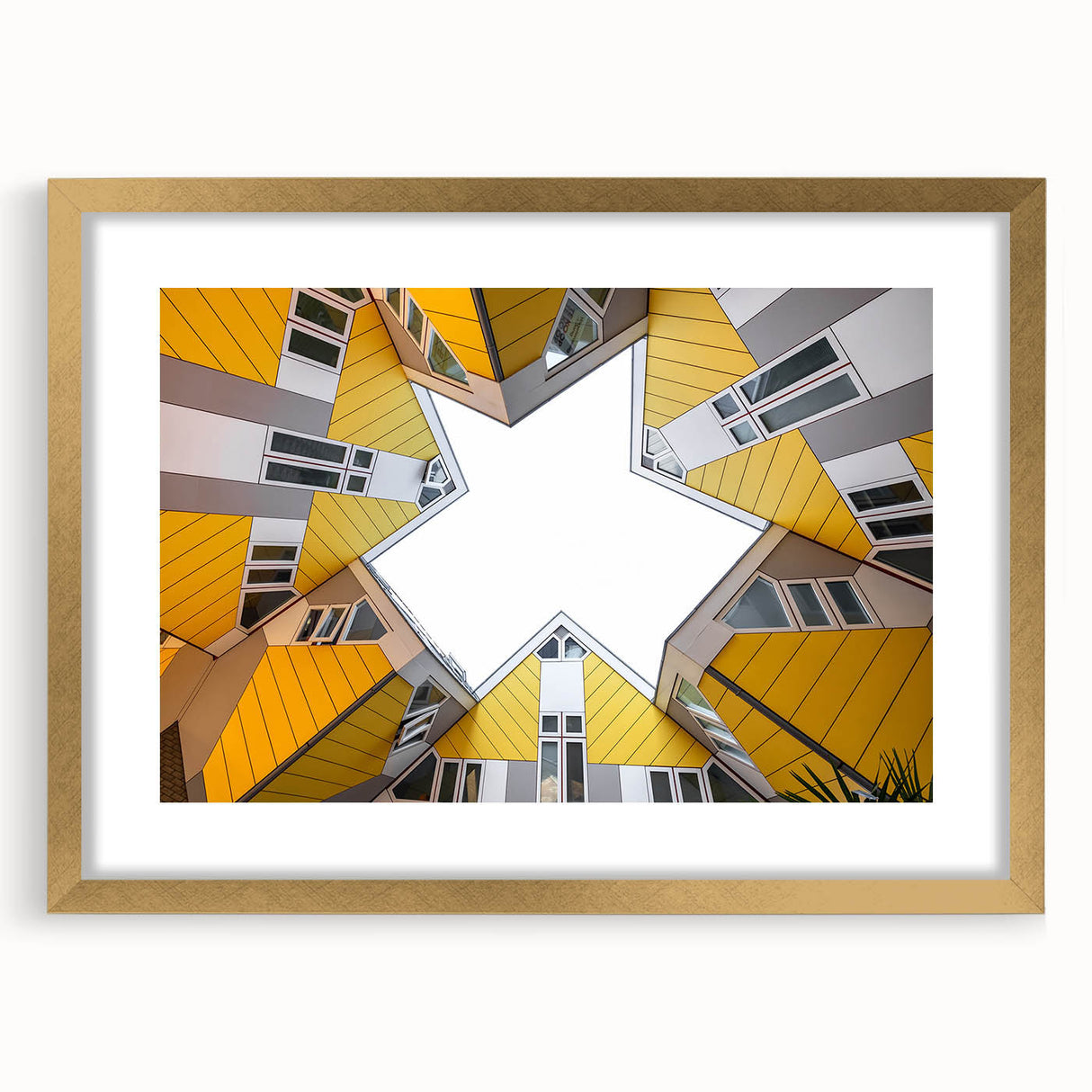 Abstract art print depicting a European scenery in muted gold and blue tones, framed with a gold mat.
