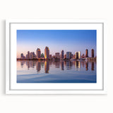 Abstract art print of San Diego skyline in muted blue and gray tones, framed in white, ideal for dining room decor.