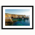 Black-framed landscape art print showcasing dramatic cliffs against a vibrant sunset, elegantly matted for a refined presentation, perfect for home decor.