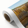 Vibrant rolled canvas artwork depicting a scenic landscape of majestic cliffs under a clear blue sky, perfect for enhancing modern home decor.