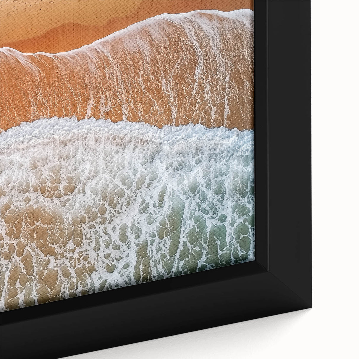 Close-up of a framed canvas showcasing a vibrant beach landscape, featuring soft waves, golden sand, and a clear blue sky, perfect for coastal home decor.