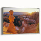 Framed canvas artwork depicting a stunning landscape of canyons, showcasing vibrant earthy tones and intricate details, set in a sleek silver frame. Perfect for home decor and nature enthusiasts.