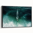 Framed canvas artwork showcasing a serene beach landscape with vibrant blue skies and gentle waves, presented in a sleek black frame, ideal for home decor.