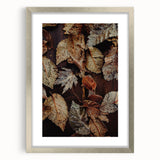 Textured abstract art print in warm autumn hues on a silver-framed canvas, suited for bedroom decor.