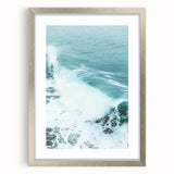 Textured abstract art print in warm orange and yellow hues, framed in silver, ideal for bedroom ambiance.