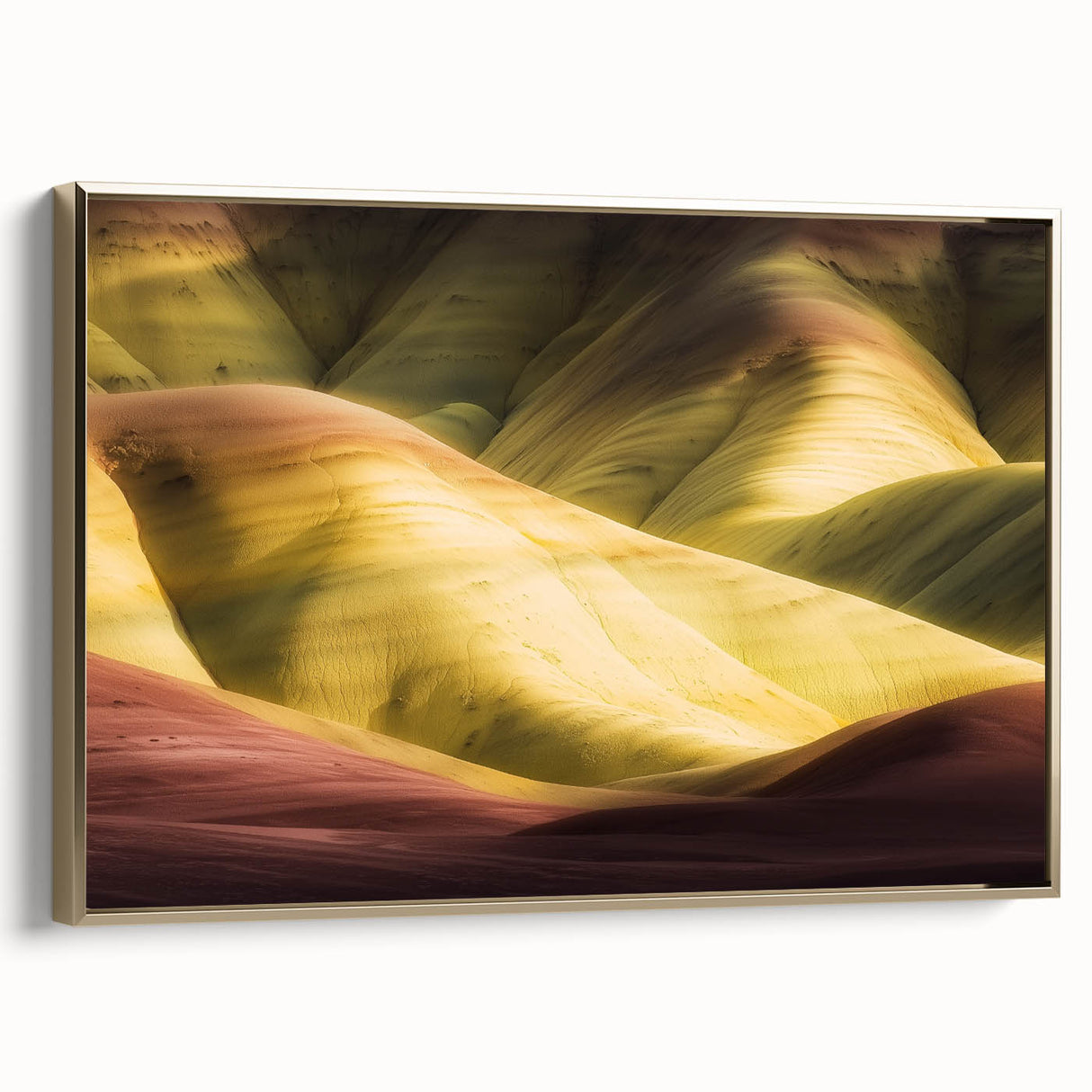 Framed canvas artwork depicting a stunning landscape of canyons in warm earth tones, featuring a sleek gold frame that enhances its elegance, ideal for home decor.