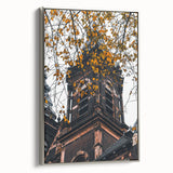 Framed canvas depicting a vintage landscape art painting with colorful autumn trees against a black background.