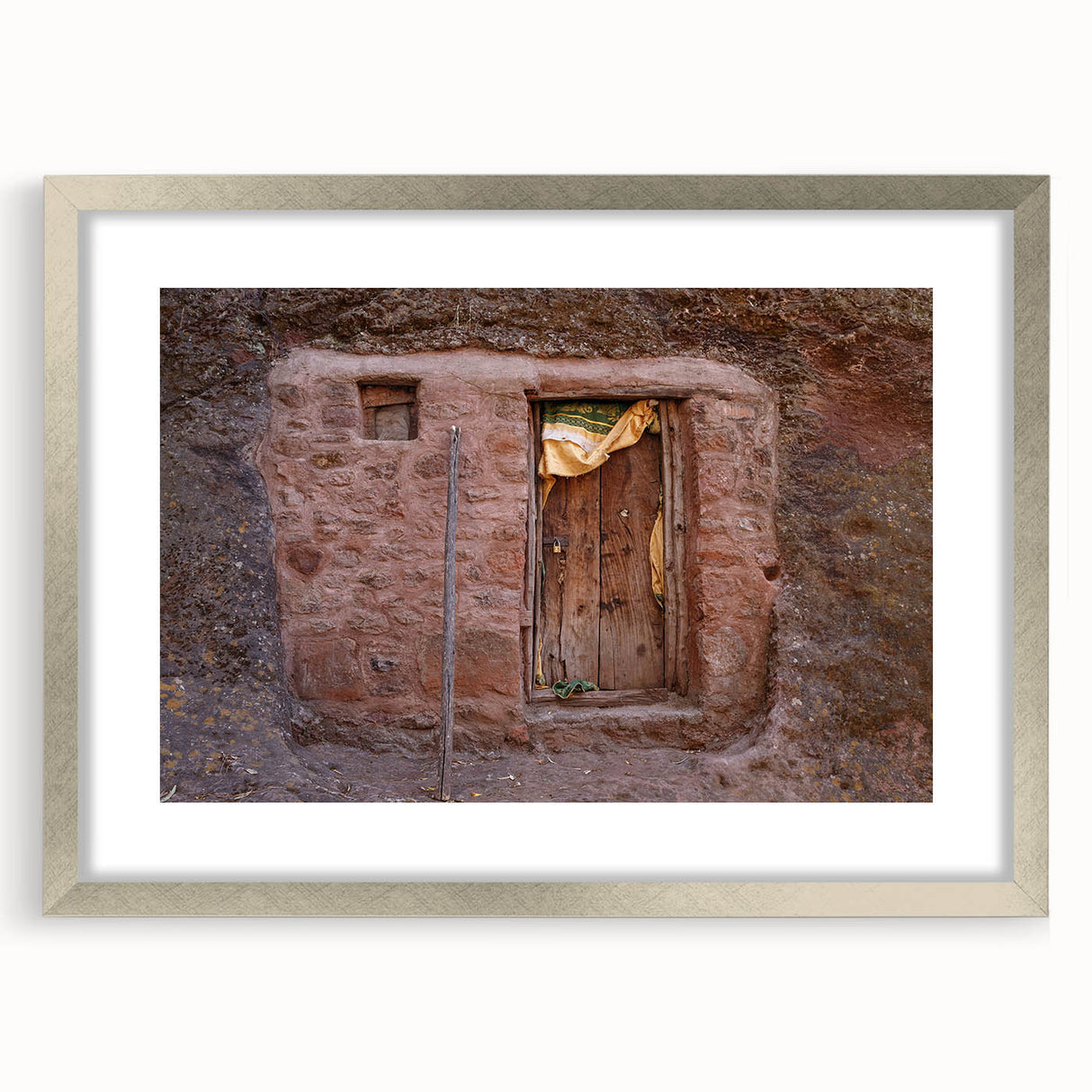 Abstract art print depicting an Ethiopian landscape in muted earth tones, framed in silver, suitable for dining room decor.