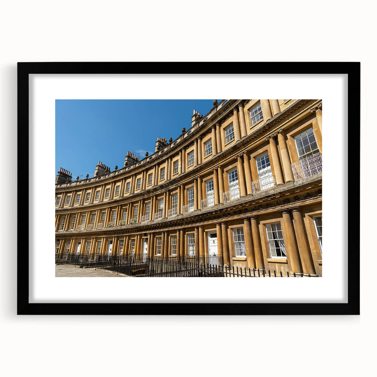 Extra large abstract art print of a colorful European scenery, displayed in a black frame with mat.