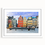 Abstract art print of a European scenery in muted blue and green tones on a framed white mat, ideal for dining room decor.