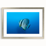 Textured abstract art print of an oceanic scene in cool blue and silver tones on a framed canvas, suitable for bedroom decor.
