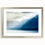 Textured art print of an abstract Alaskan scenery in muted gray and blue tones, framed in silver, ideal for bedroom decor.