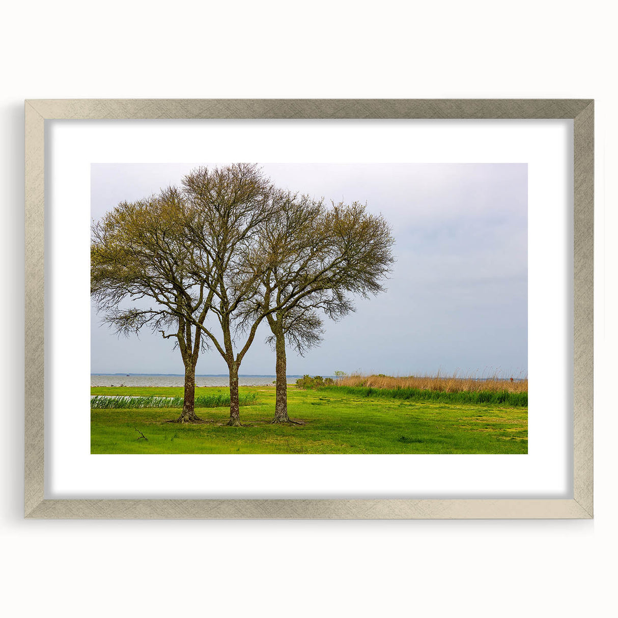 Textured abstract art print of the Outer Banks in muted gray and blue tones, framed in silver, ideal for bedroom wall decor.