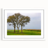 Abstract art print of the Outer Banks in muted blue and beige tones on a framed white canvas.