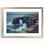Silver-framed landscape print showcasing dramatic cliffs and serene ocean views, featuring a white mat for added elegance, perfect for modern home decor.