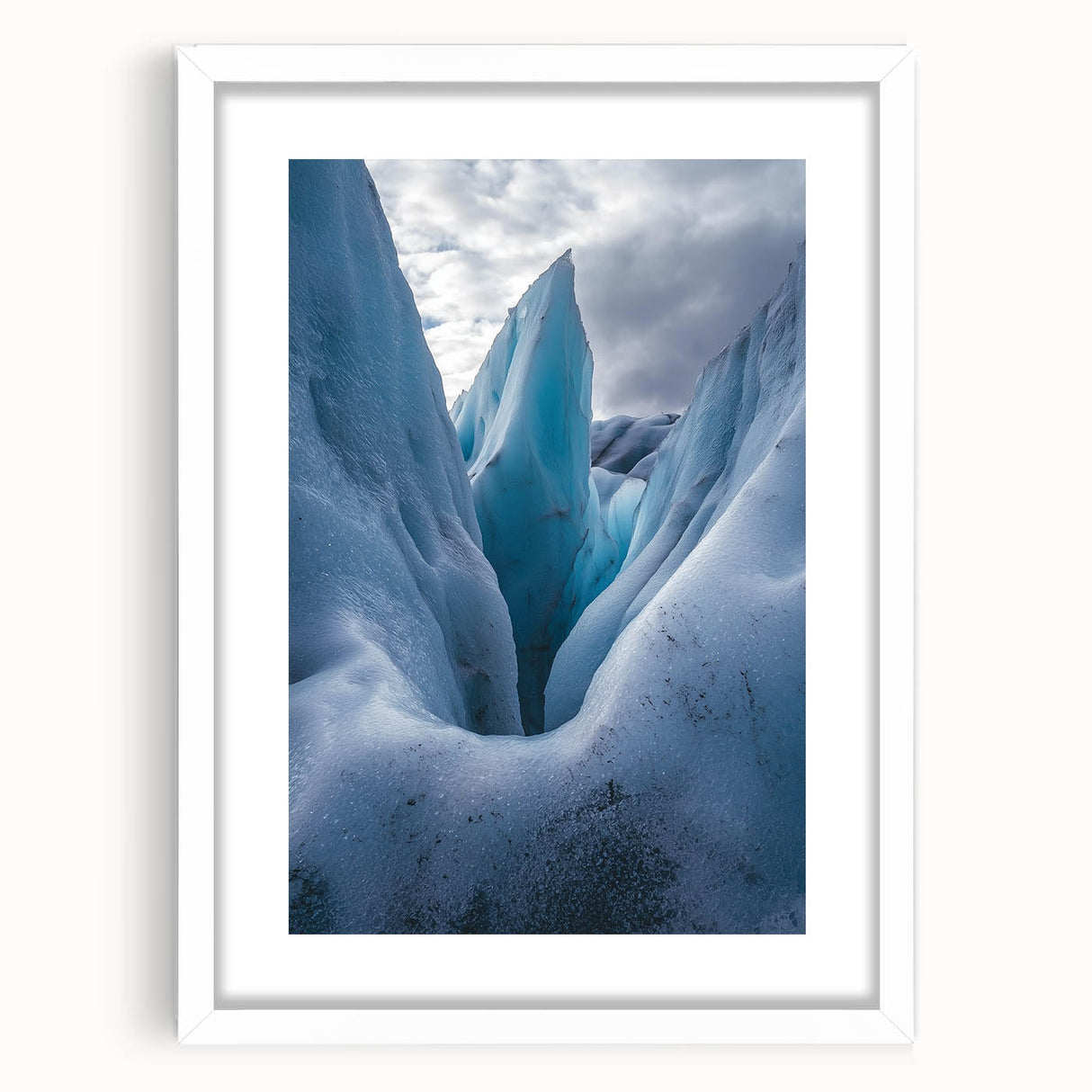 Framed landscape artwork depicting rugged cliffs under a serene sky, featuring a white mat and sleek black frame, ideal for enhancing modern home decor.