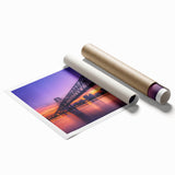 Rolled print of a vibrant landscape bridge design, showcasing lush greenery and a serene river, packaged securely in a protective cardboard tube for easy transport. This artwork enhances home decor with its rich colors and tranquil scene.