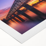 Rolled canvas depicting a vibrant landscape bridge design with rich colors and intricate details, elegantly packaged in a protective cardboard tube for safe delivery.
