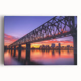Stretched canvas artwork depicting a stunning landscape view of a bridge surrounded by lush greenery and vibrant sky colors, perfect for home decor or office spaces.