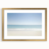 Gold-framed landscape print showcasing a serene beach scene, featuring soft waves and a clear sky, ideal for coastal home decor. Perfect for enhancing living spaces.