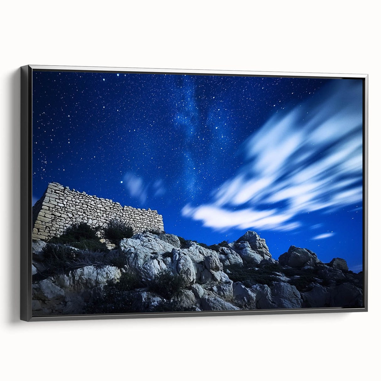 Framed canvas artwork depicting dramatic cliffs against a serene sky, showcased in a sleek black frame, perfect for enhancing modern home decor.