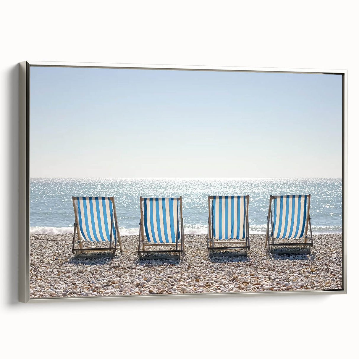 Framed canvas artwork of a serene beach landscape with silver edges, showcasing vibrant blue skies and tranquil ocean waves, ideal for modern home decor.