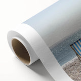 Vibrant rolled canvas art depicting a serene beach landscape with soft waves, blue skies, and golden sands, ideal for coastal-themed decor and interior design.