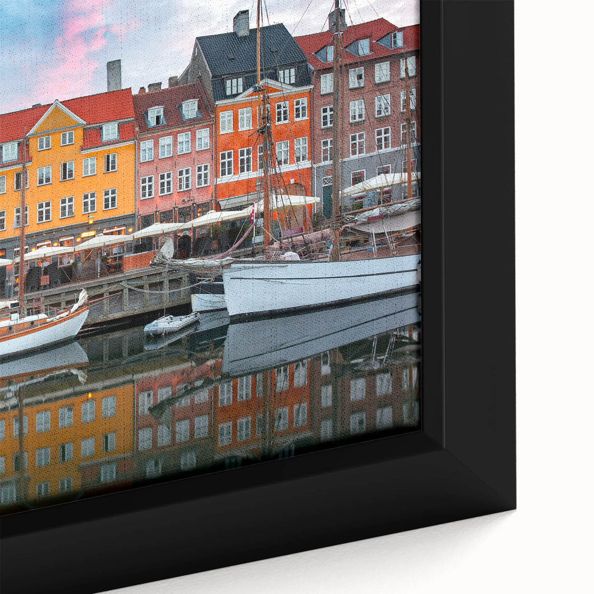 Close-up of a black framed canvas depicting a colorful, textured European scenery, ideal for living room decor.