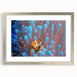 Textured art featuring abstract oceanic shapes in cool blue and white tones, presented in a silver frame with mat.